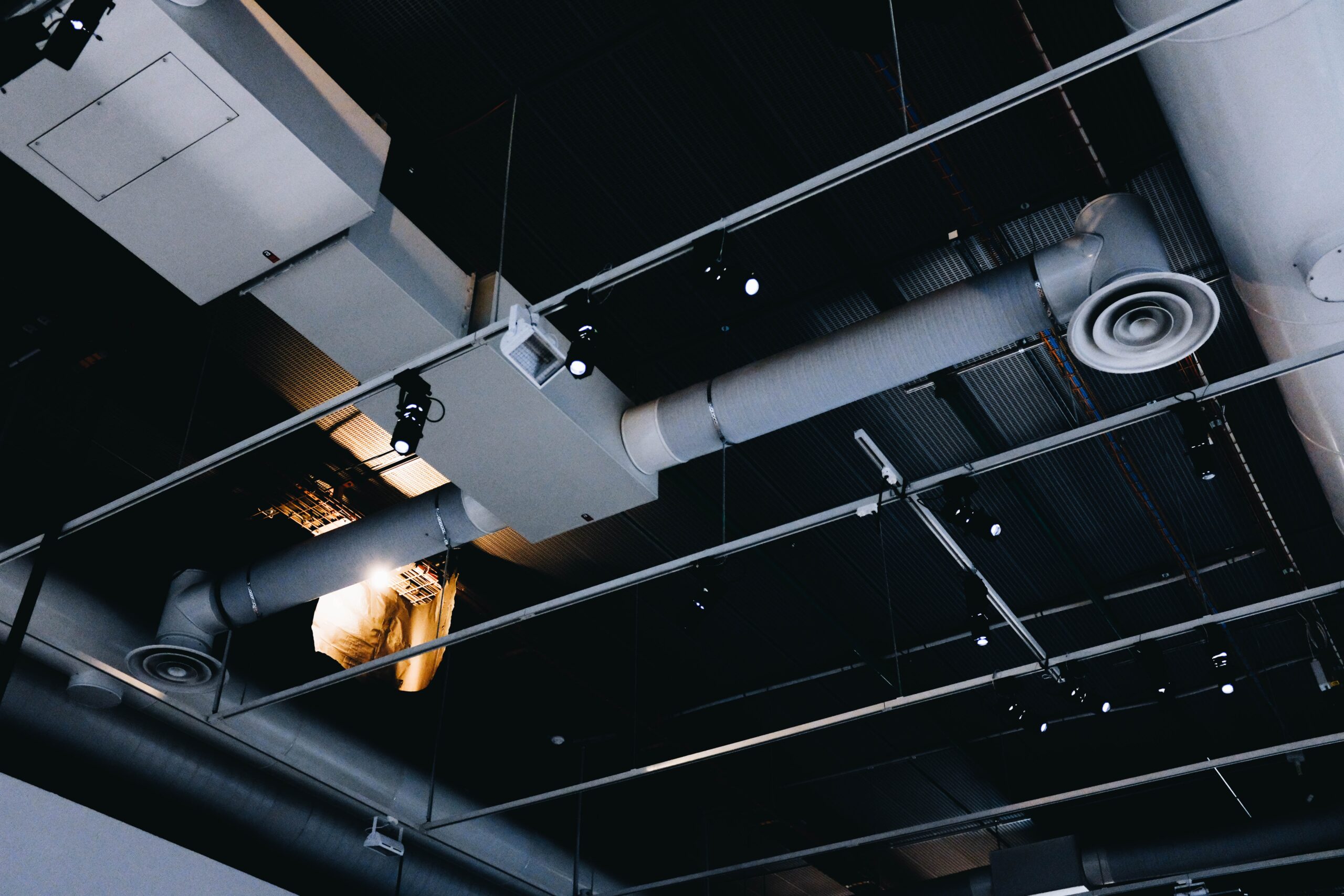 Low angle shot of a metal black ceiling with white ventilation pipes instalacje fotowoltaiczne Wrocław